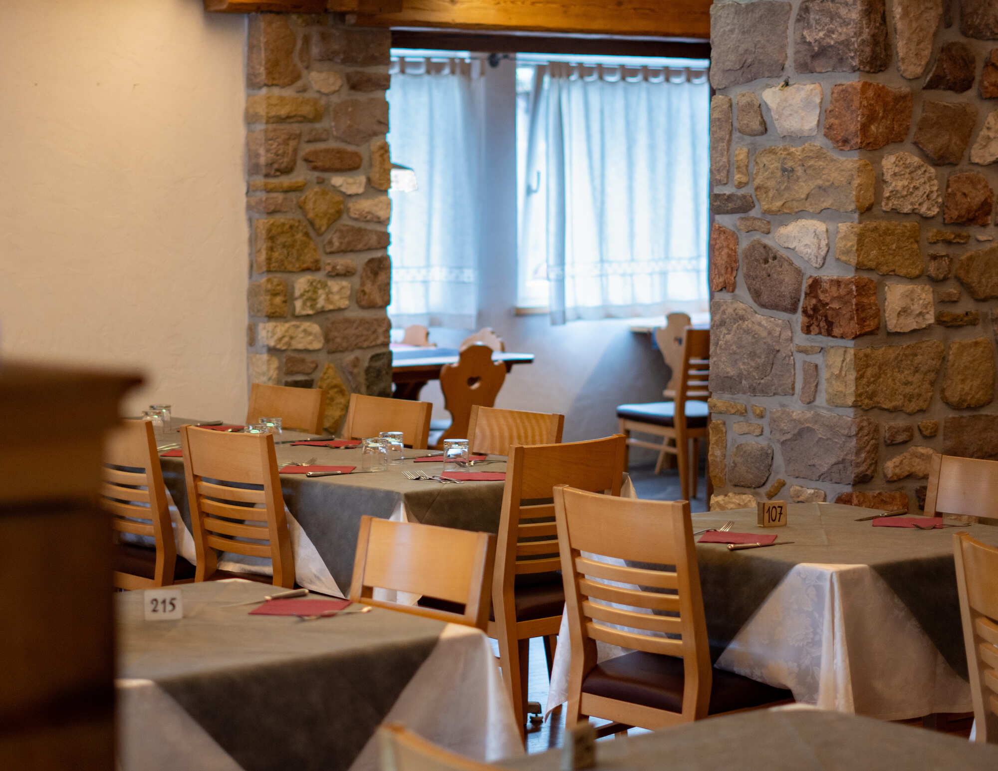 Sala con pareti in pietra e arredi in legno di montagna